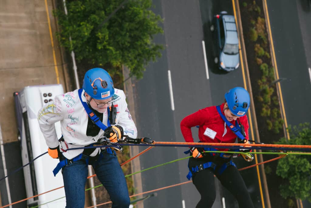 John and Christy rappelling down the building.