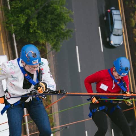 John and Christy rappelling down the building.